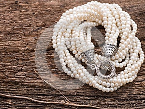 Pearl necklace on wood background
