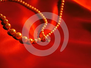 Pearl necklace jewelry on red satin background for valentines day