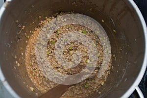 Pearl Porridge in a Saucepan, Close up, in Metallic Saucepan with wooden Spoon. Top view.