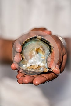 Pearl in shell on open hands