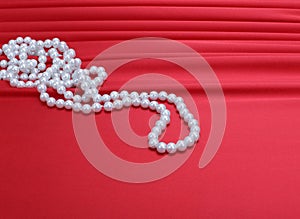 Pearls beads on red silk
