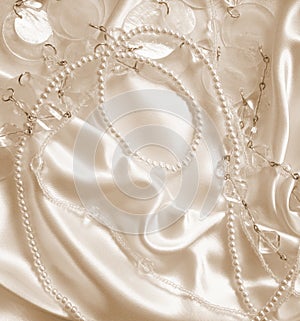 Pearls and nacreous beeds on silk as wedding background. In Sepi