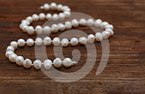 Pearls string wooden table closeup