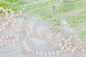 Pearls, wedding rings and bouquet