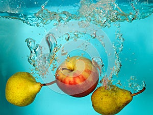 Pears and apple splash of water on blue bckground