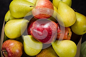 Pears and apples on a dark background