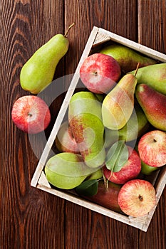 Pears and apples in wooden box on table