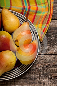 Pears on the dish and cloth on the old wood backing