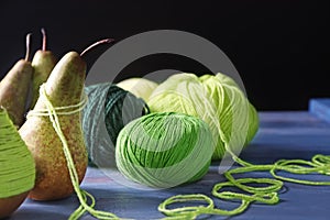 Pears with knitting yarn on wooden table