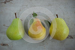 Pears with leaves on wooden board