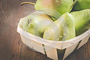 Pears in a wooden box on a dark background/ripe pears in a wattled box on a wooden background, selective focus