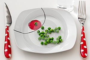 Peas on a plate with a glass of water, dieting concept