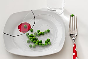 Peas on a plate with a glass of water, dieting concept