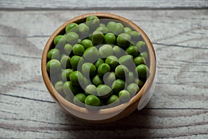 peas in a wooden bowl on a rustic table photo