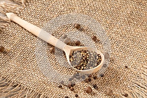 Peasant style setting with pepper grinder and finely ground black pepper on fabric napkin
