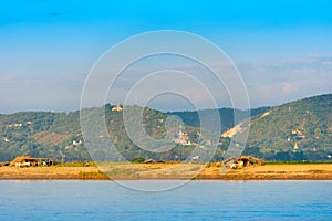 The peasants working on the bank of the river Irrawaddy, Mandalay, Myanmar, Burma. Copy space for text. Vertical.