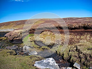 Peat erosion and loss from old peat diggings on coastal wetlands at Lunna Ness, Shetland, UK.