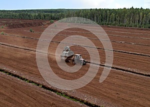 Peat Harvester Tractor on Collecting Extracting Peat. Mining and harvesting peatland. Area drained of the mire are used for peat