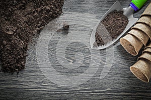 Peat pots soil hand spade on wooden board