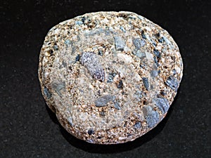 Pebble of Arkose sandstone on dark background photo