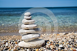 Pebble beach with balancing stone pyramid close-up. Calm and balance concept.