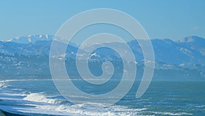 Pebble Beach Of The Black Sea With A Coastline. Surf On A Background Of The City. Real time.
