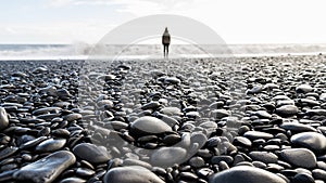 Pebble beach with a blurred person standing in the background