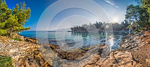 Pebble beach on Brac island with pine trees and turquoise clear ocean water, Supetar, Brac, Croatia