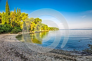 Pebble beach on Brac island with turquoise clear ocean water, Supetar, Brac, Croatia