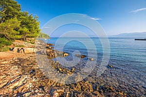 Pebble beach on Brac island with turquoise clear ocean water, Supetar, Brac, Croatia photo