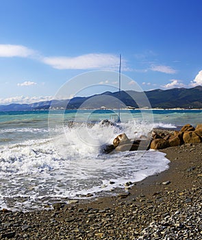 Pebble beach in the resort of Kabardinka, Krasnodar region, Black sea. Waves and surf on a pebble beach.