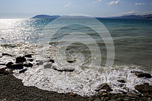 Pebble beach in the resort of Kabardinka, Krasnodar region, Black sea. Waves and surf on a pebble beach.
