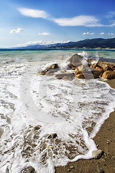 Pebble beach in the resort of Kabardinka, Krasnodar region, Black sea. Waves and surf on a pebble beach.