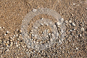 Pebble beach textured background. Close-up of round stones and sand on Mediterranean sea. Paleokastritsa beach on Corfu