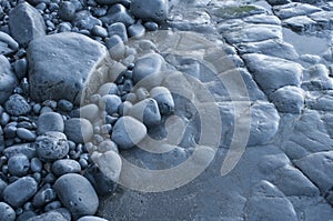 Pebble of different sizes and exposed rock in low tide in Cantabrian beach