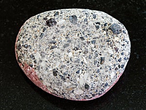 pebble of gray Arkose sandstone on dark background