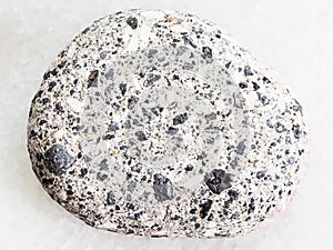 pebble of gray Arkose sandstone on white marble