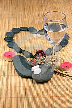 Pebble Heart, Glass, and dried flowers on the rattan background