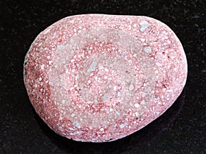 pebble of pink Arkose sandstone on dark background