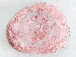 pebble of pink Arkose sandstone on white marble