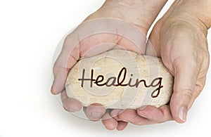 Pebble stone in hands. Concept for healing sign