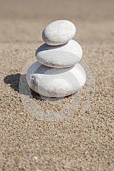Pebble stones on balance on sand