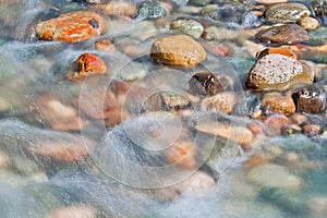 Pebble stones in the river water close up view