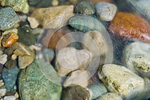 Pebble stones in the river water close up view
