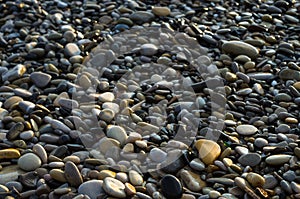 pebble stones on the sea beach, the rolling waves of the sea with foam