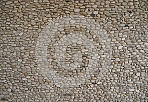 Pebble wall made of small stones of different size and shape. Background and texture.
