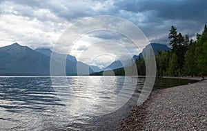 Pebbled Beach of Lake McDonald in Glacier National Park, Montana with Mountains in Background photo