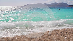 Pebbles on the background of an azure sea wave. Pebble beach. Beach in Kas,