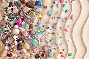 Pebbles, gemstones and shells on beach sand