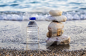 pebbles in pyramid one over another and bottle with drinking water
